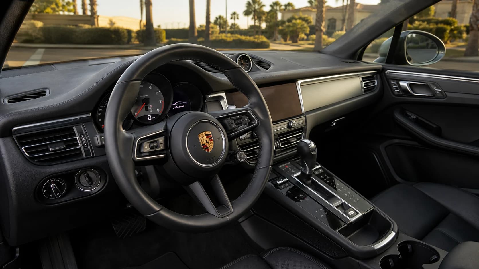 Porsche Macan cockpit with the steering wheel, dashboard, and controls visible